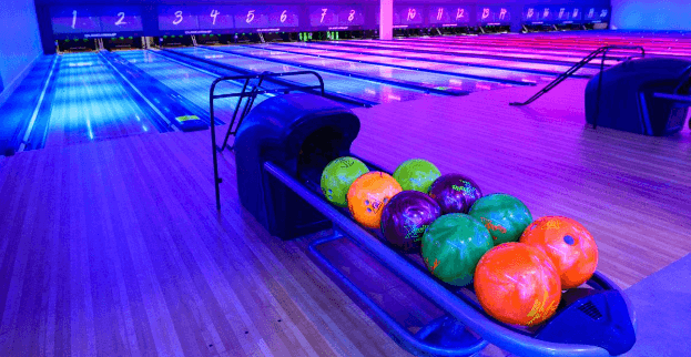 Row Of Colourful Bowling Balls On Tenpin Lane In Uv Light (1) (1)