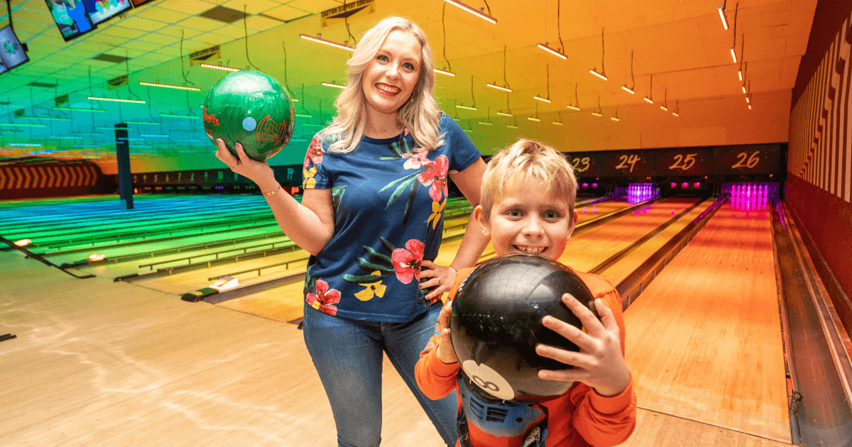 Woman And Child Smiling Whilst Holding Bowling Balls (1)