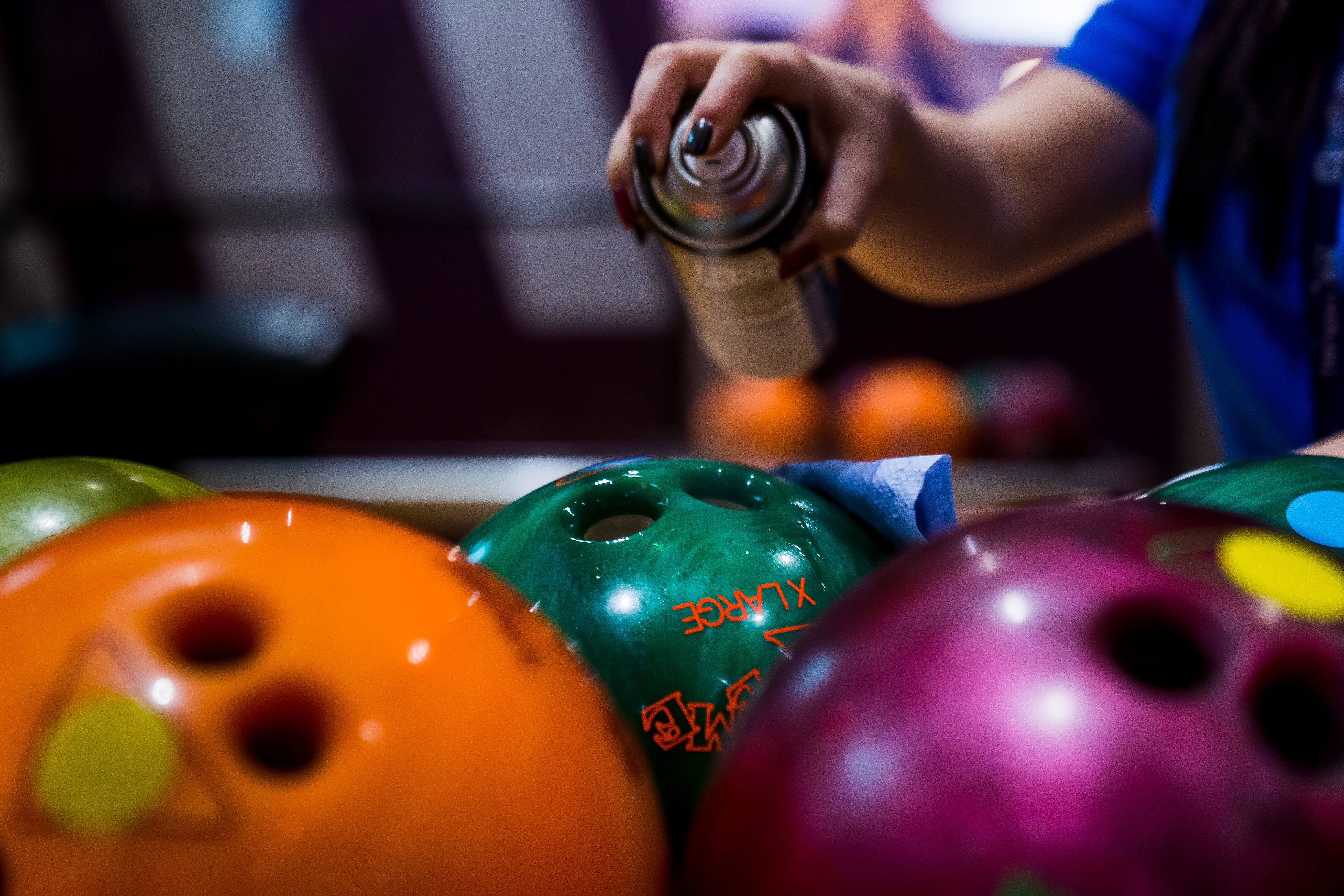 Bowling Balls Being Sprayed Cleaned