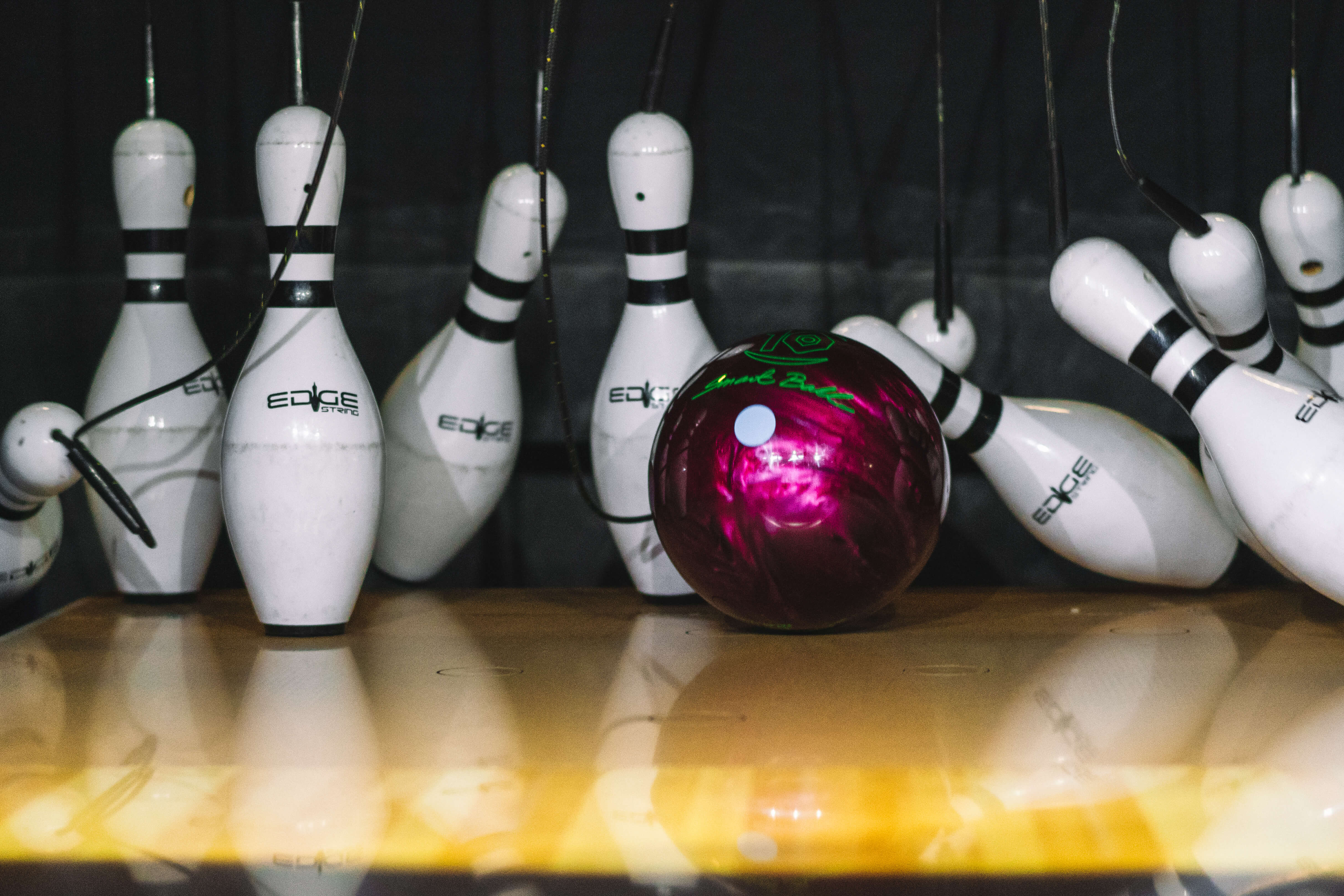 White Bowling Pins Being Knocked Over At Tenpin Bowling 8