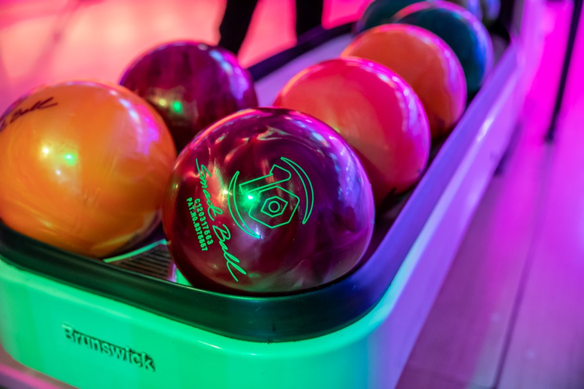 Close up of multi coloured bowling balls lined up in rack
