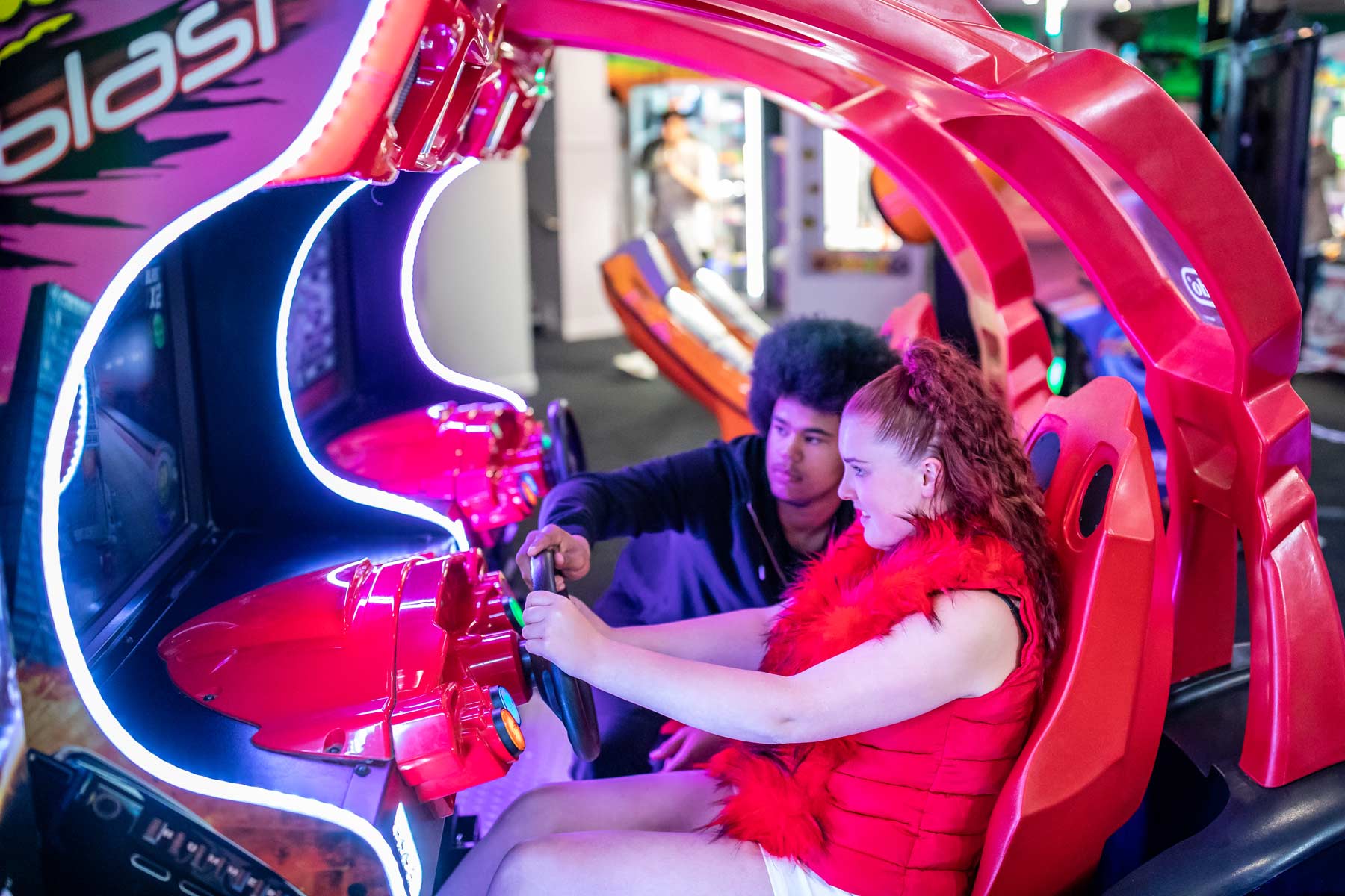 Girl Enjoying A Car Racing Game In The Arcade