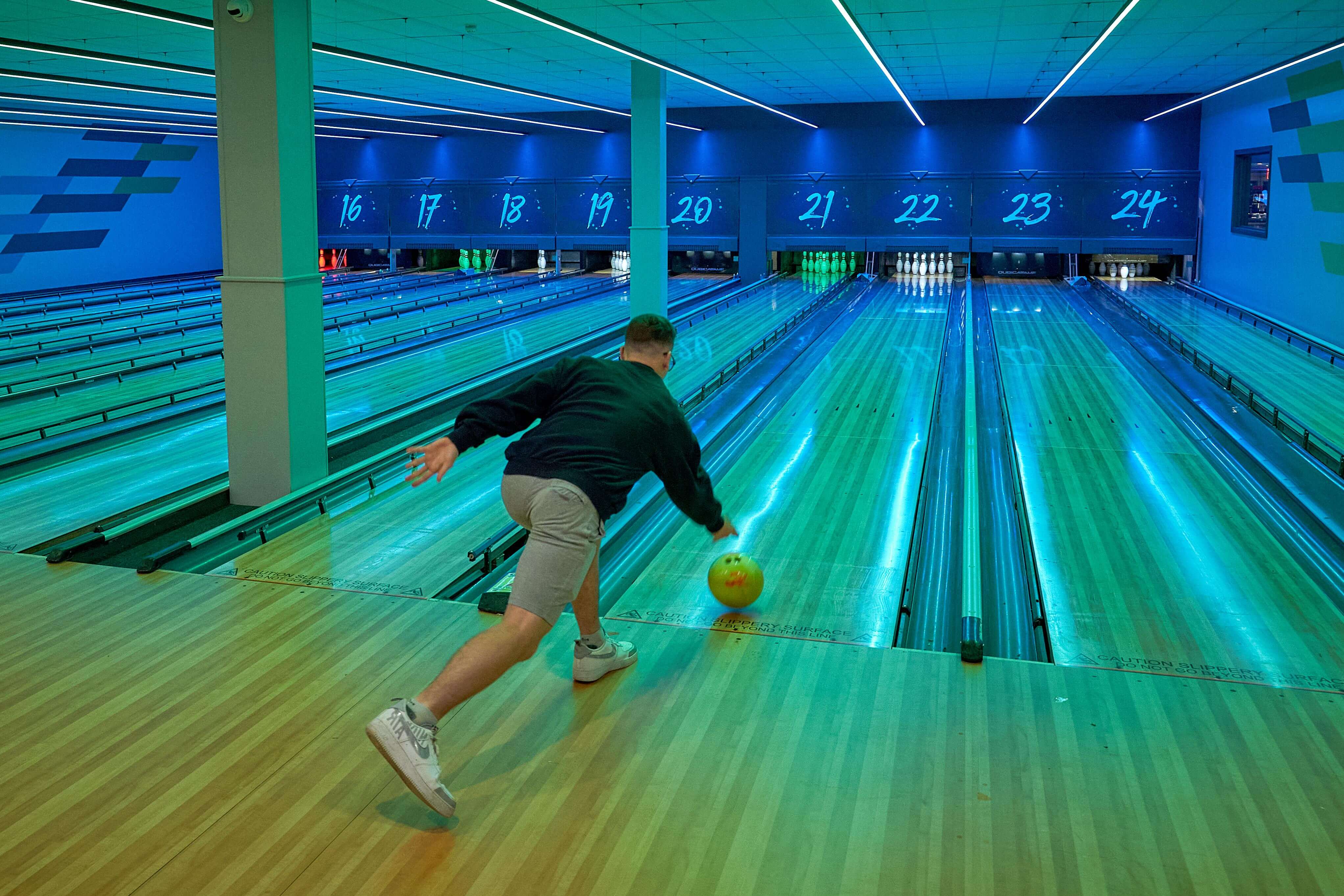 Young Man Rolling A Bowling Ball Down The Lane At Tenpin