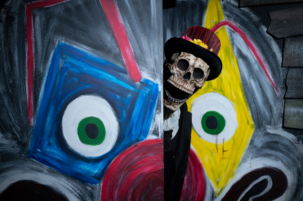 creepy clown peeping head round door of themed escape room
