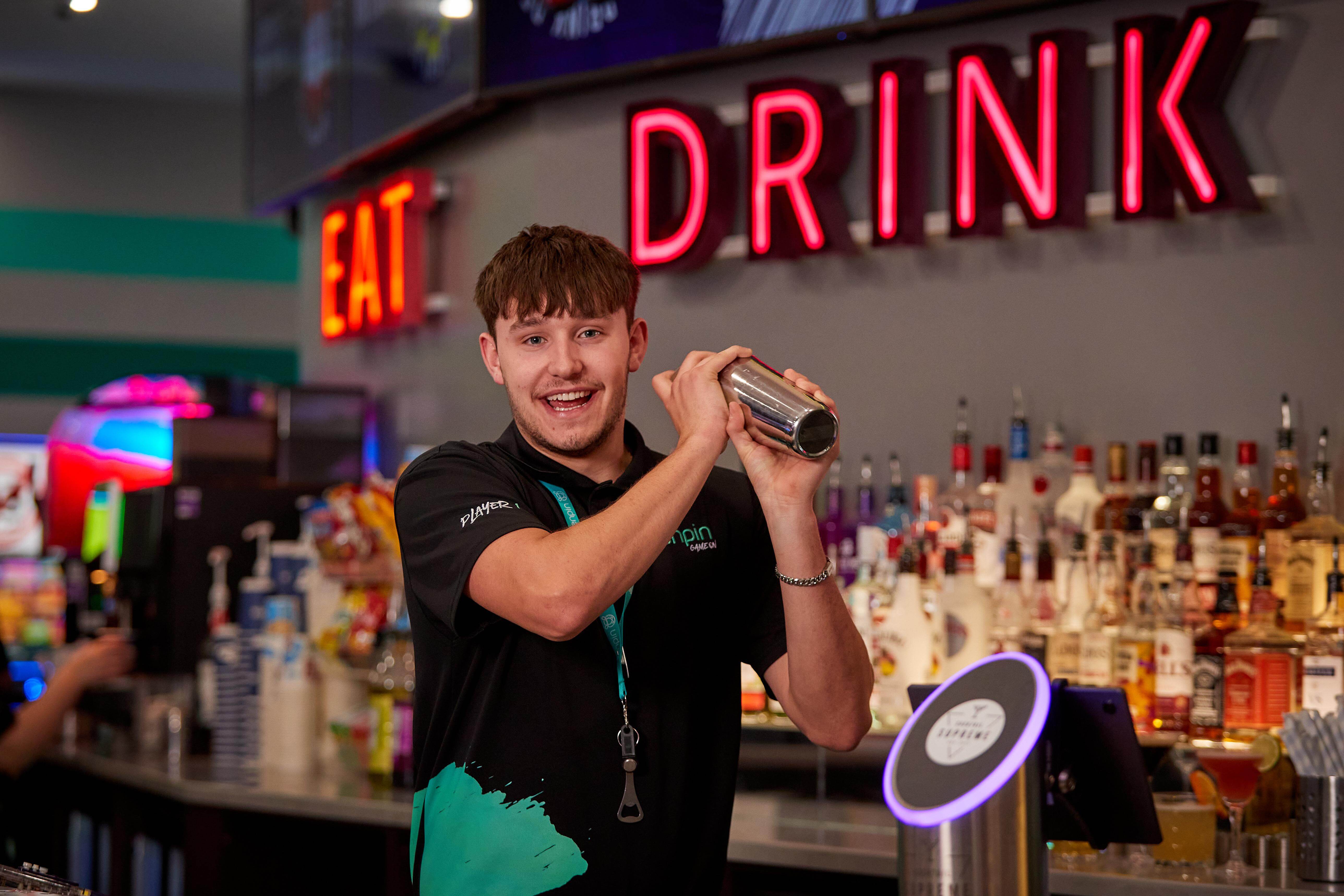 Tenpin male member of staff shaking cockails