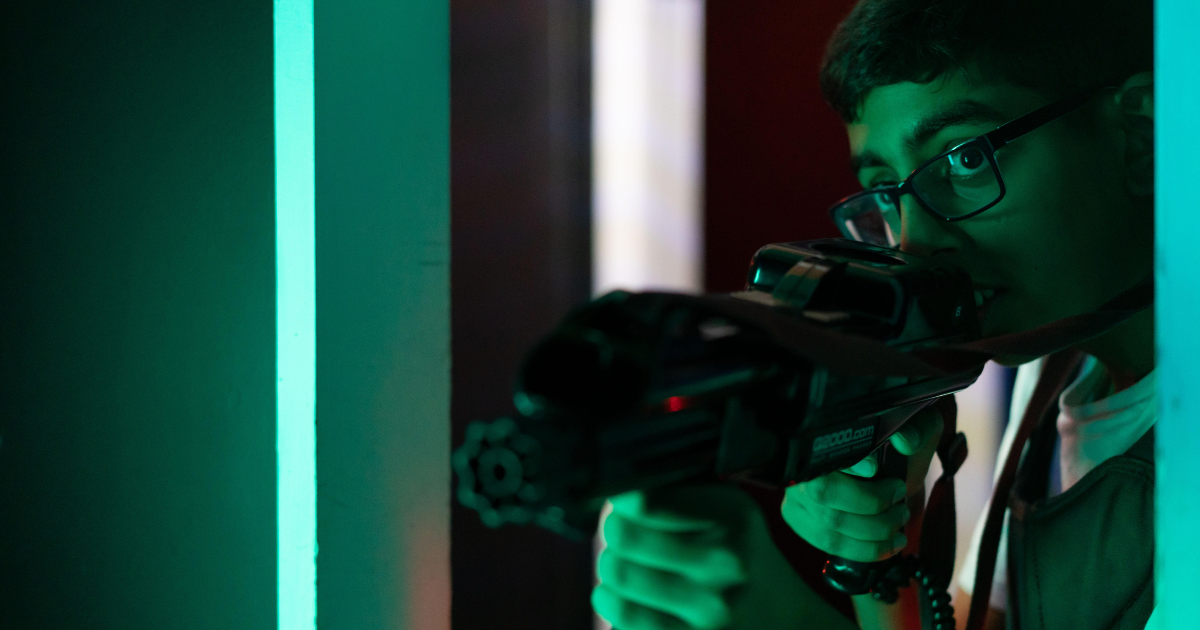 Young Boy Taking Cover Behind A Wall With Laser Gun