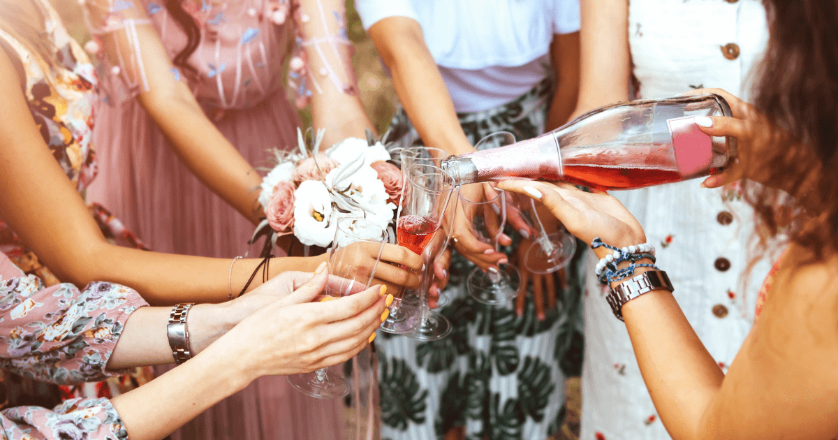 A Group Of Girls Holding Glasses Whilst Pouring Wine (1)