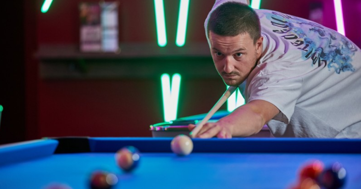 Young Man Aiming At White Ball In Pool At Tenpin