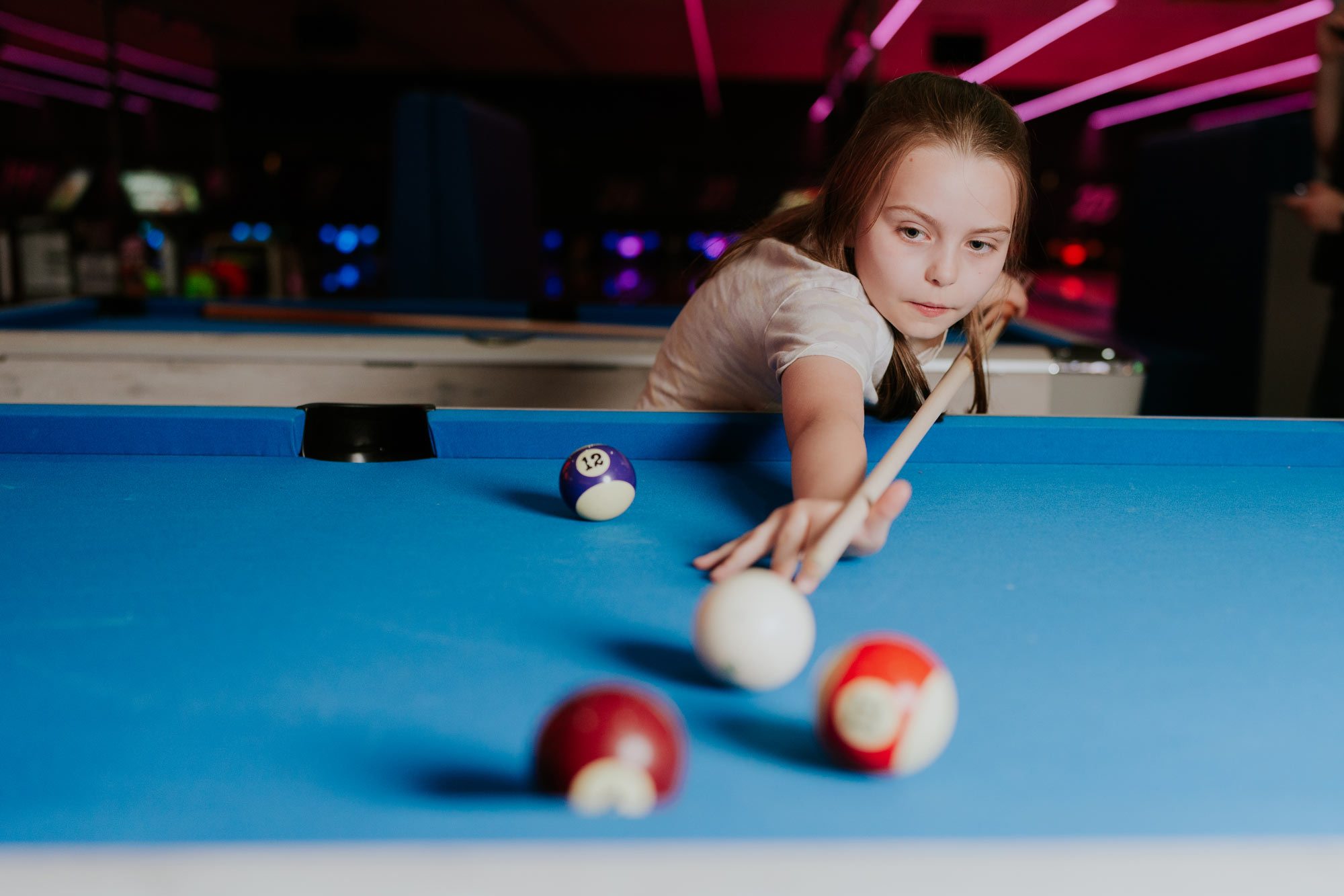 Little girl taking pool shot