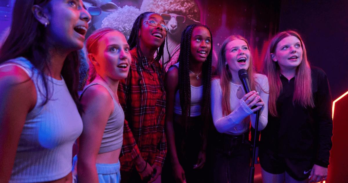 A Group Of Girls Singing Karaoke At Tenpin