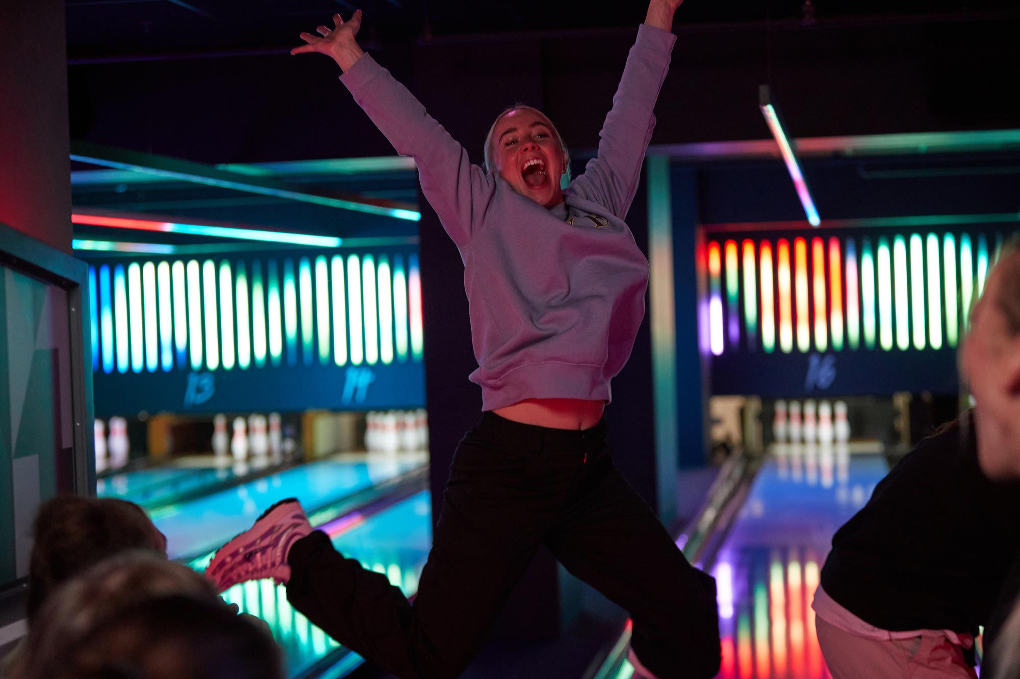Bowling Sheffield woman jumping in air to celebrate on Sheffield bowling lanes