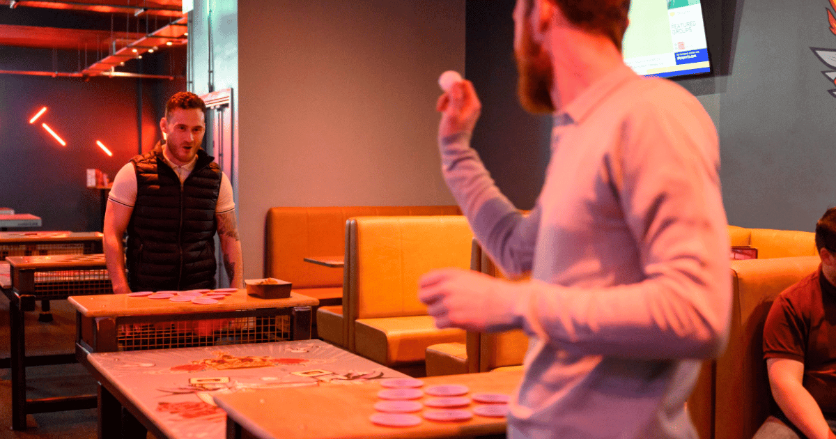 2 Young Men Playing Beer Pong At Tenpin (1)