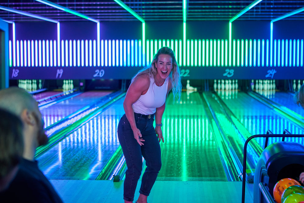 Lady celebrating bowling shot on bowling lanes