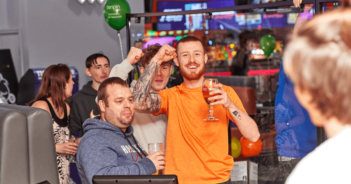 A Group Of Friends Eating Hot Dog And Fries At Tenpin Bowling (1) (1)