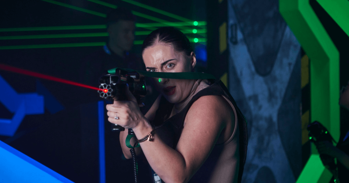 Young Woman Pointing A Laser Gun With A Red Laser (1)