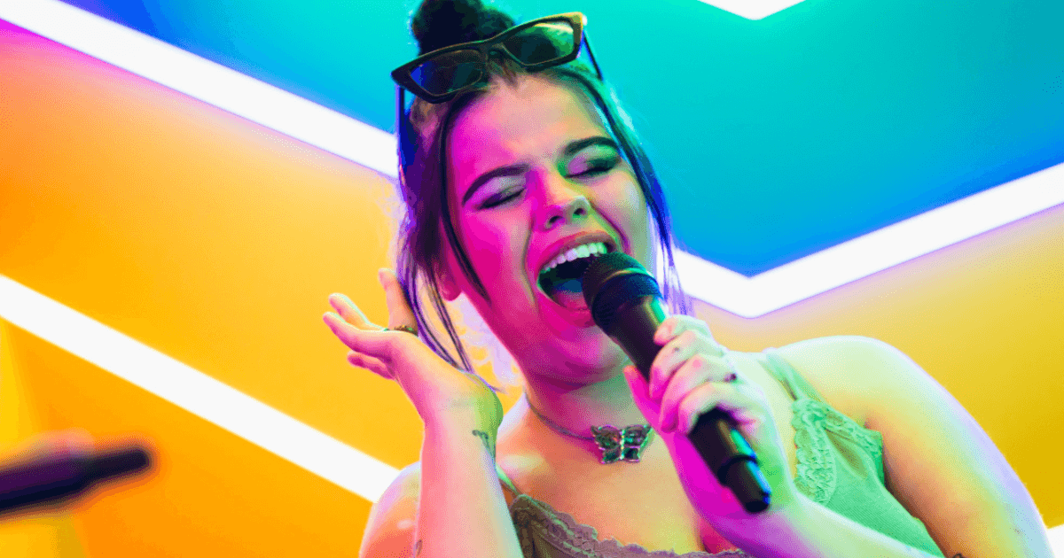 Singing Into A Microphone In Front Of A Colorful Background (1)