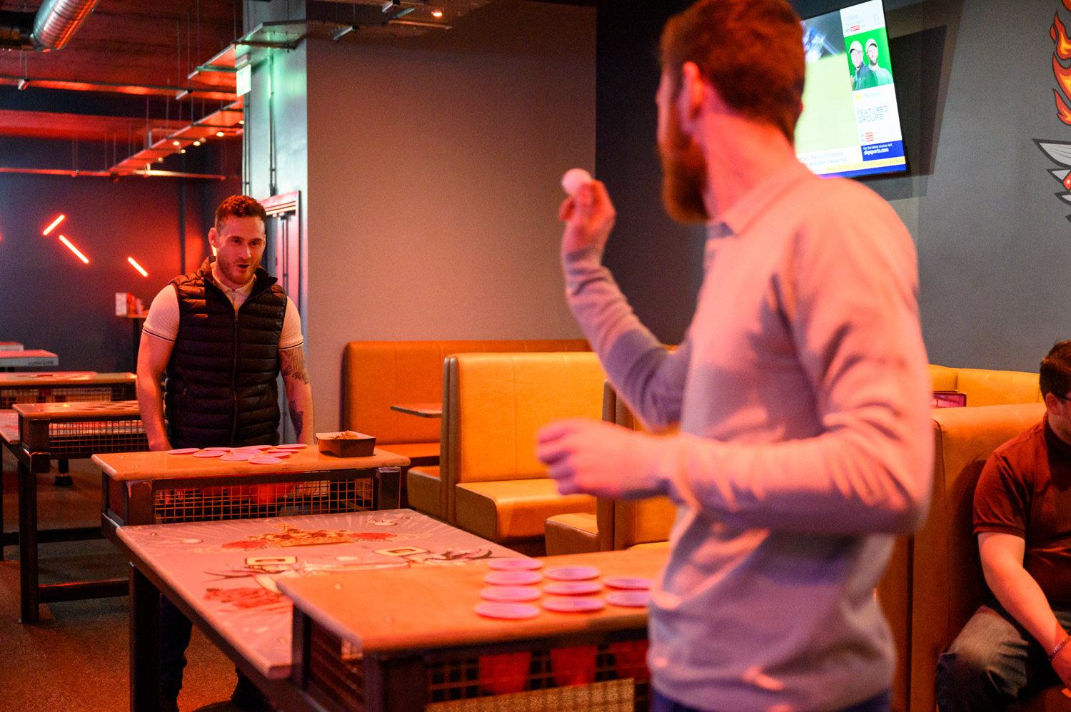 2 Friends Playing Beer Pong In A Tenpin Centre